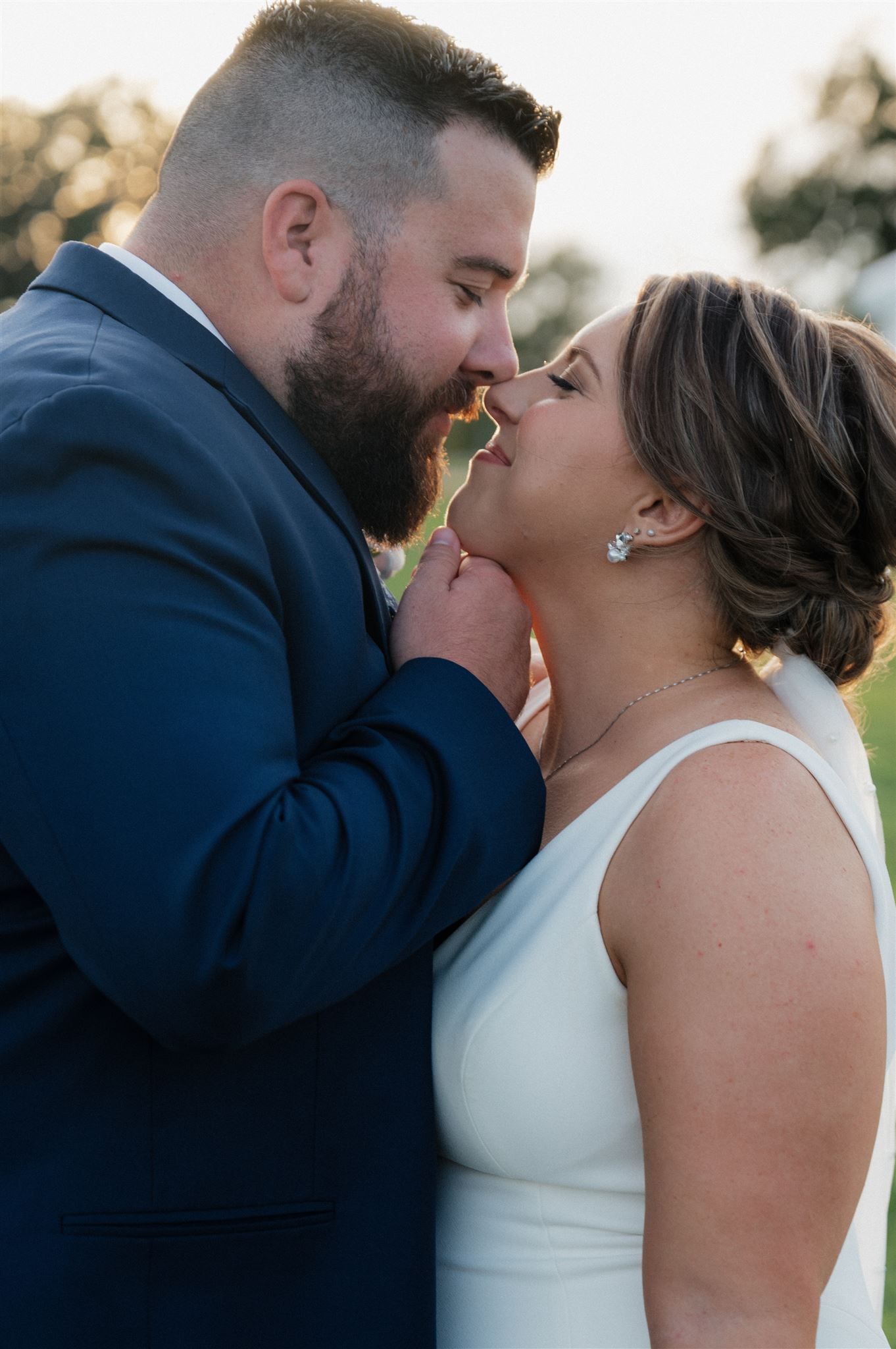 Intimate romantic moment between newlyweds sharing a playful bite.