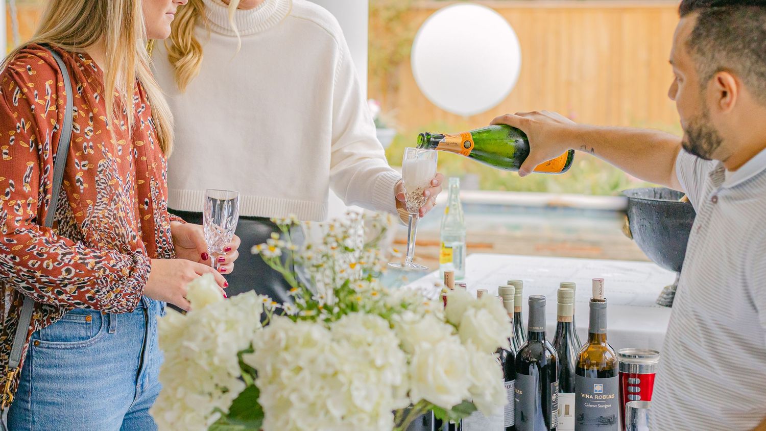 a bartender pours champagne into a woman's glass at an engagement party