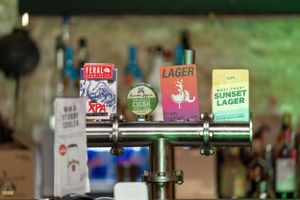 Bar taps featuring Feral XPA, Lager, and West Coast Sunset Lager beer on display.