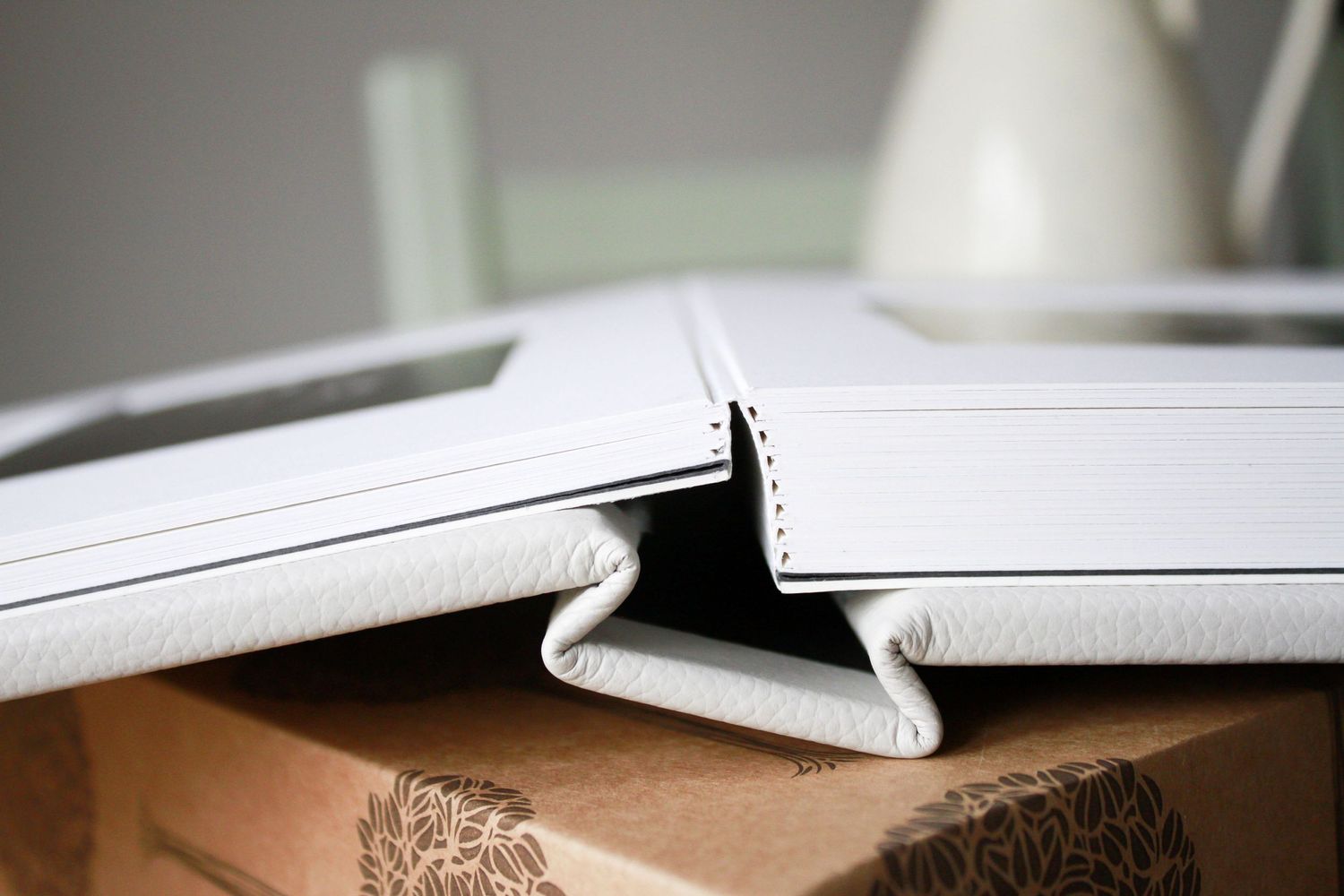 Close-up detail of white leather photo album binding showing craftsmanship.