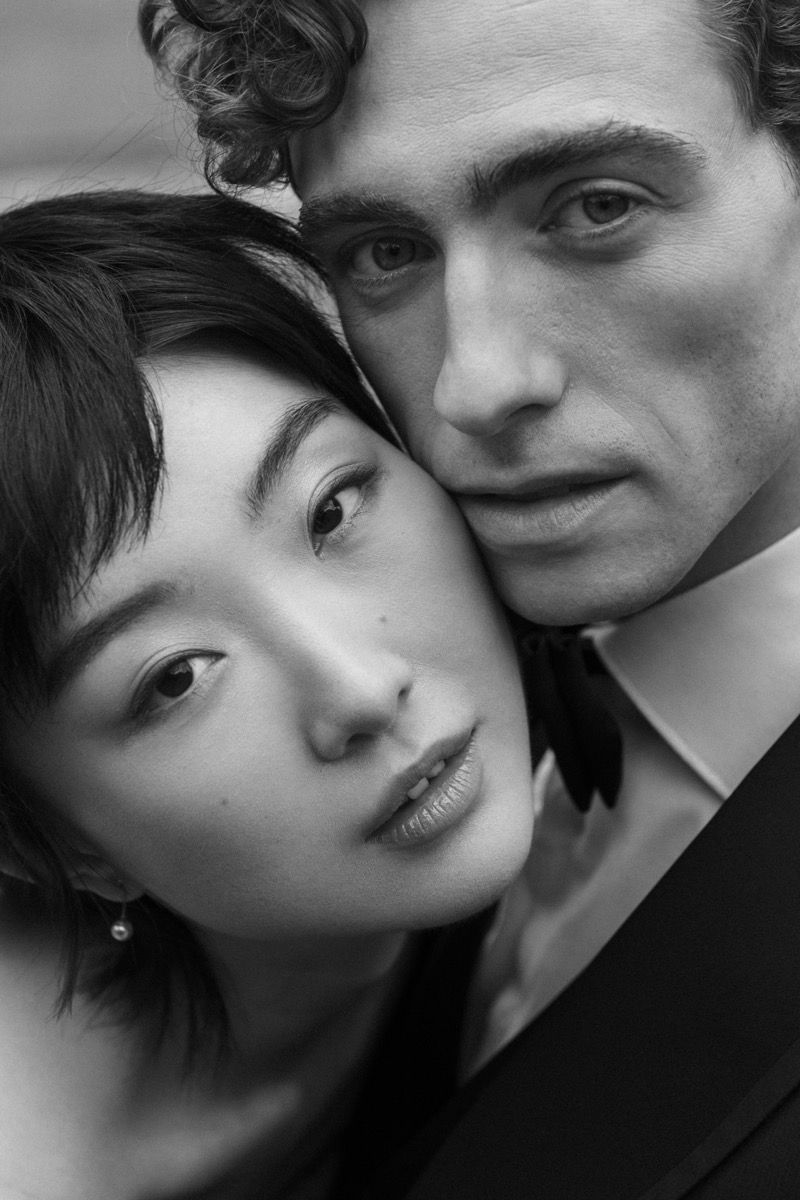Intimate black and white close-up portrait of a wedding couple in formal attire.
