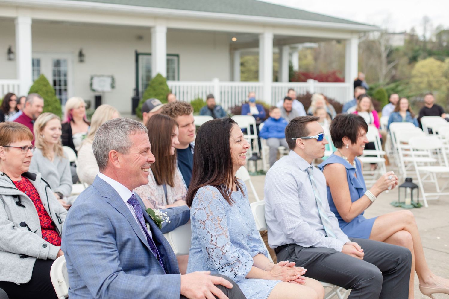 Wedding guests seated in rows watching an outdoor ceremony at an elegant venue.
