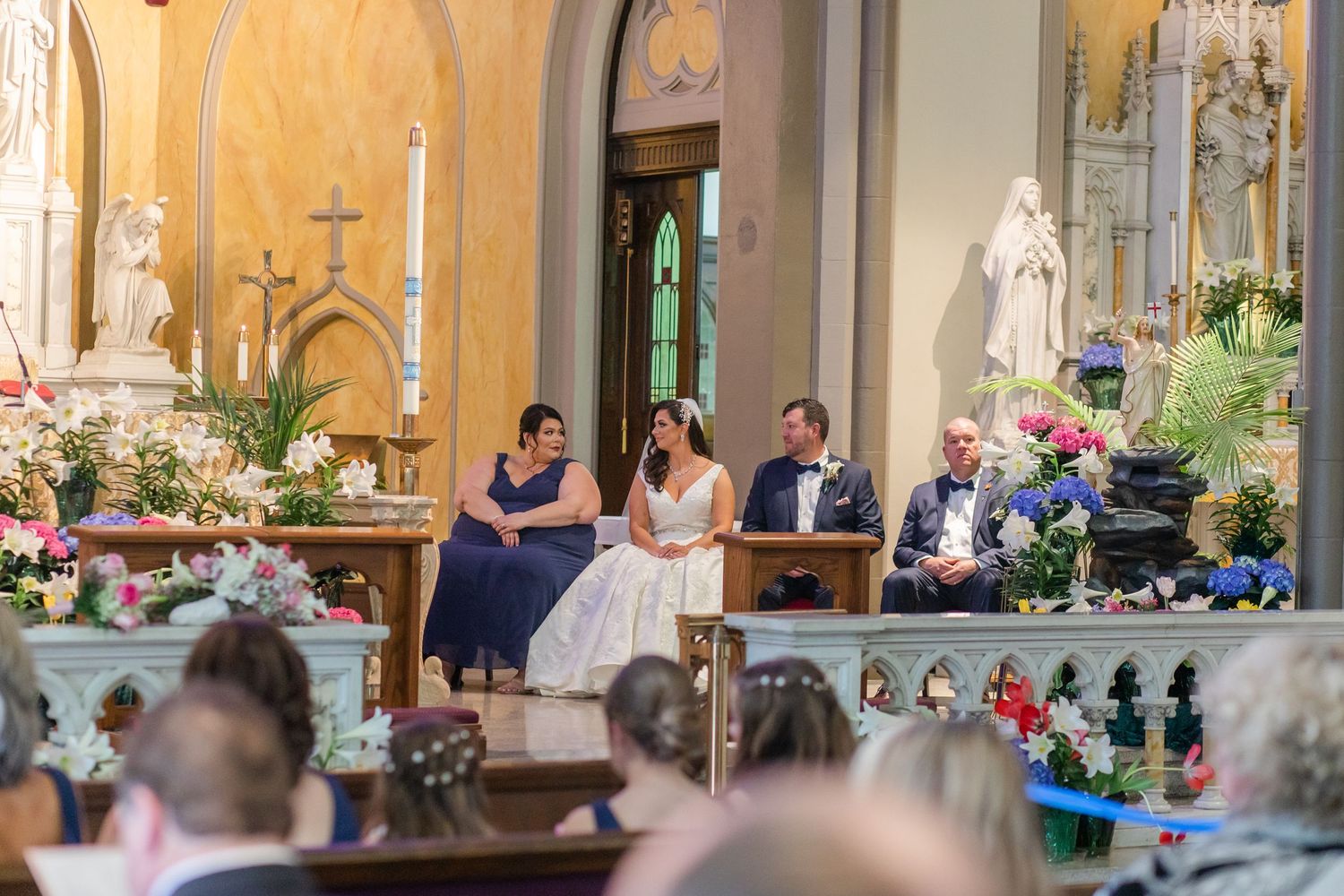 Elegant church wedding ceremony with vaulted ceilings and ornate altar decorations.