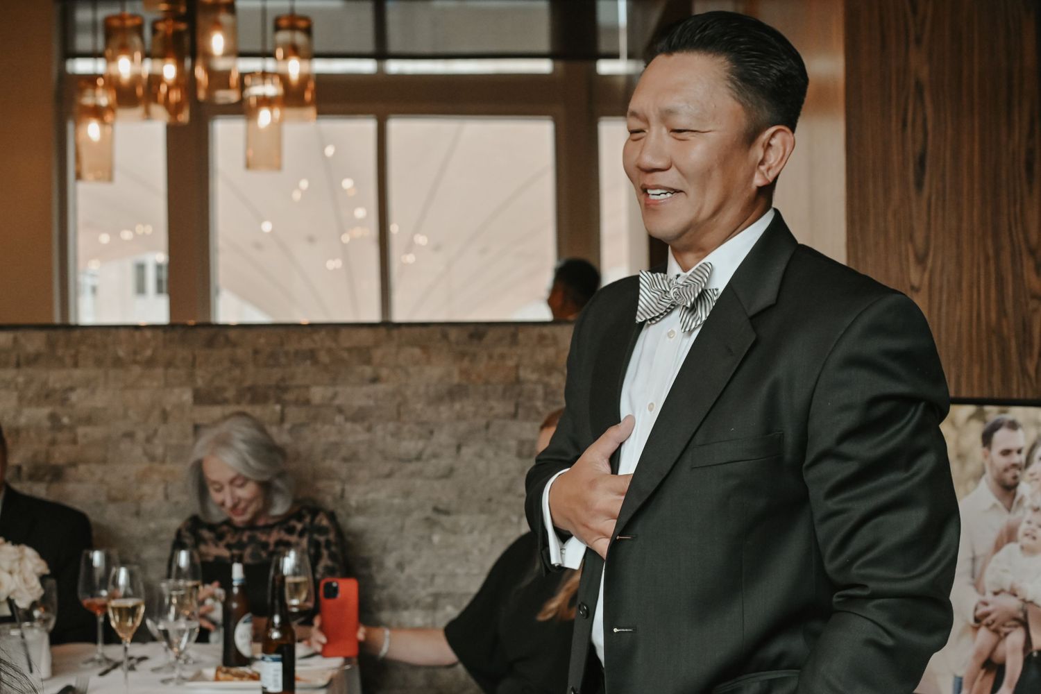 Wedding reception gathering in an industrial-style venue with brick walls.