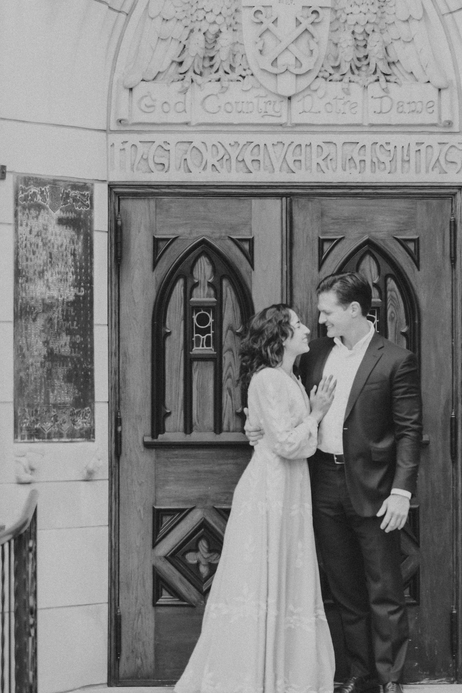 Couple embracing outside God Country Notre Dame door at Basilica