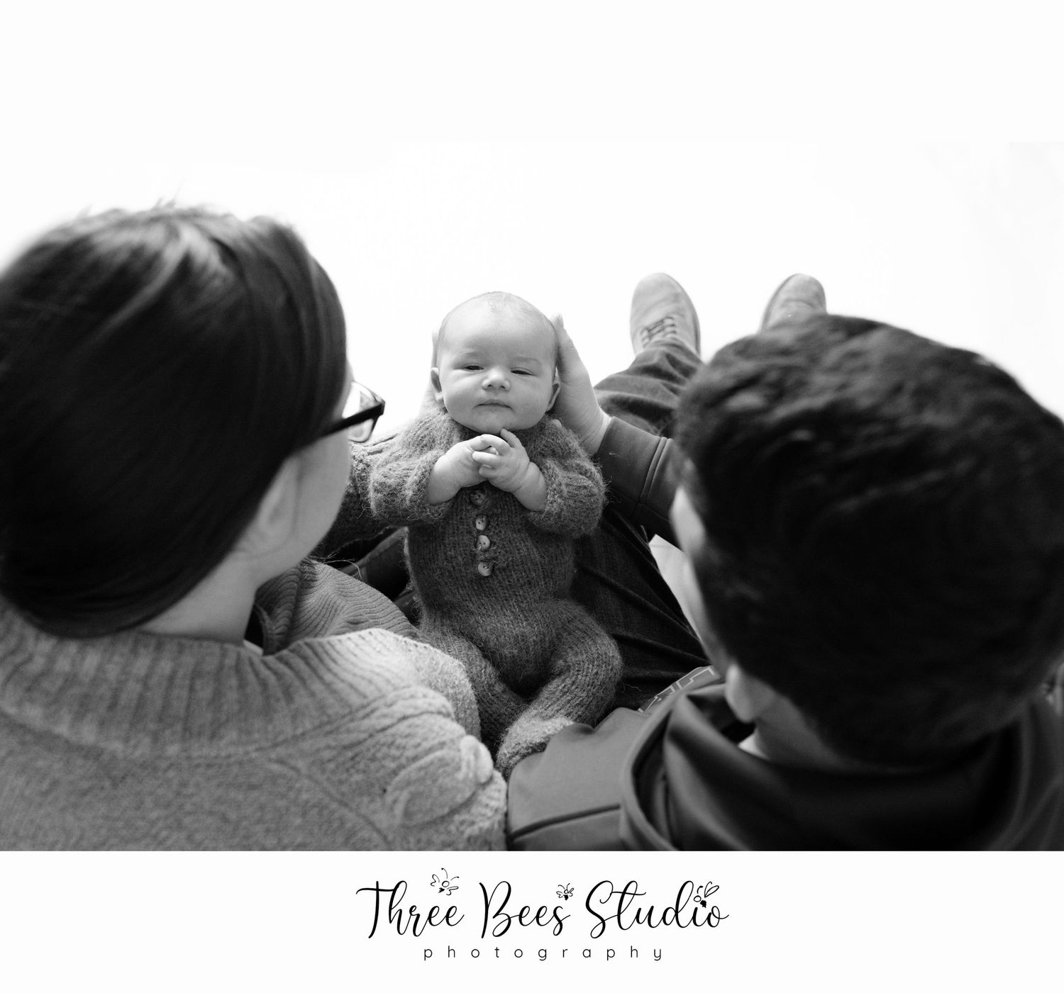 Black and white family moment captured from above.