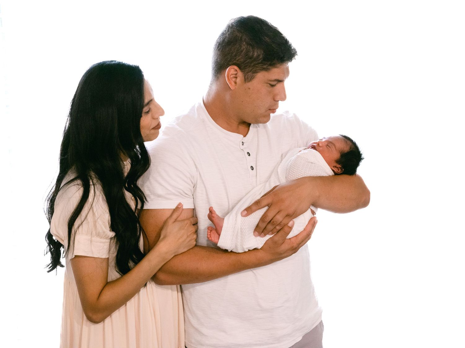 dad holding a baby in his arms and mom next to him in Syracuse Utah, Davis County family and newborn.