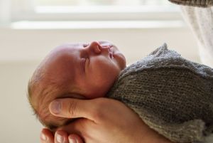 Close up portrait newborn in dads hands in Clintonville, Ohio by Jamie Macey Photography