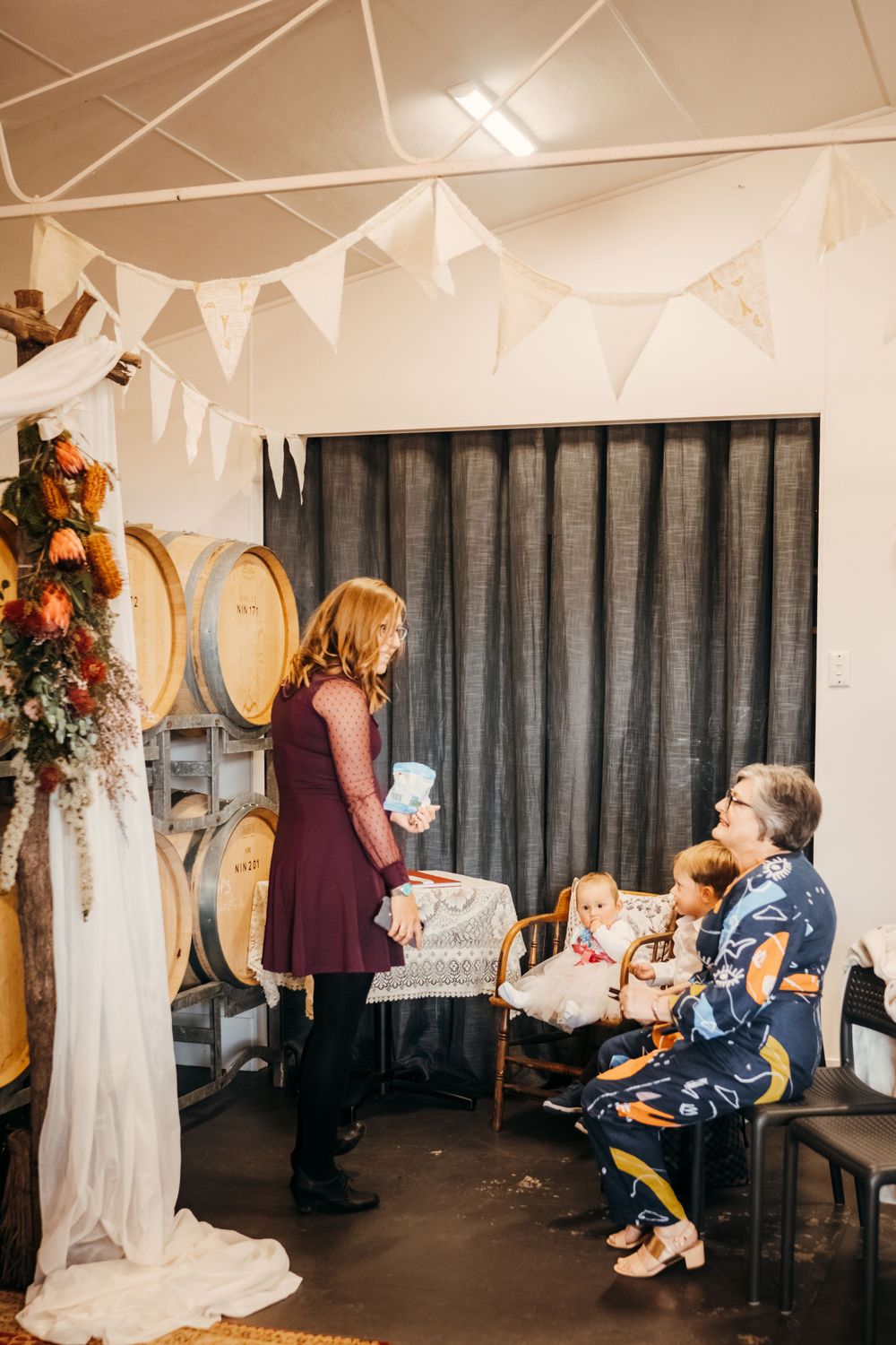 Wedding venue decorated with white bunting and wine barrels features elegant decor.
