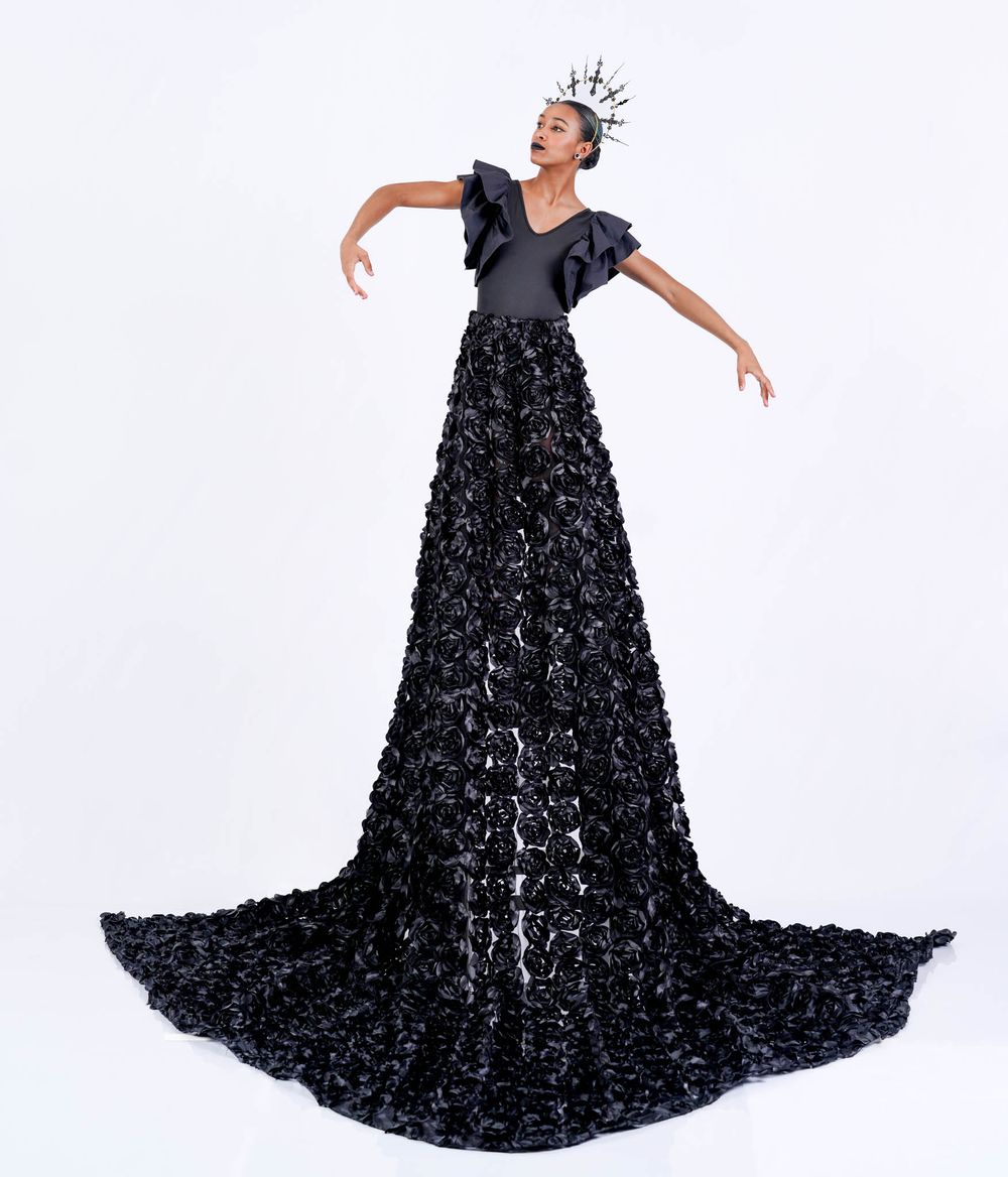 A dramatic black ballgown with voluminous textured skirt is showcased in an artistic portrait.