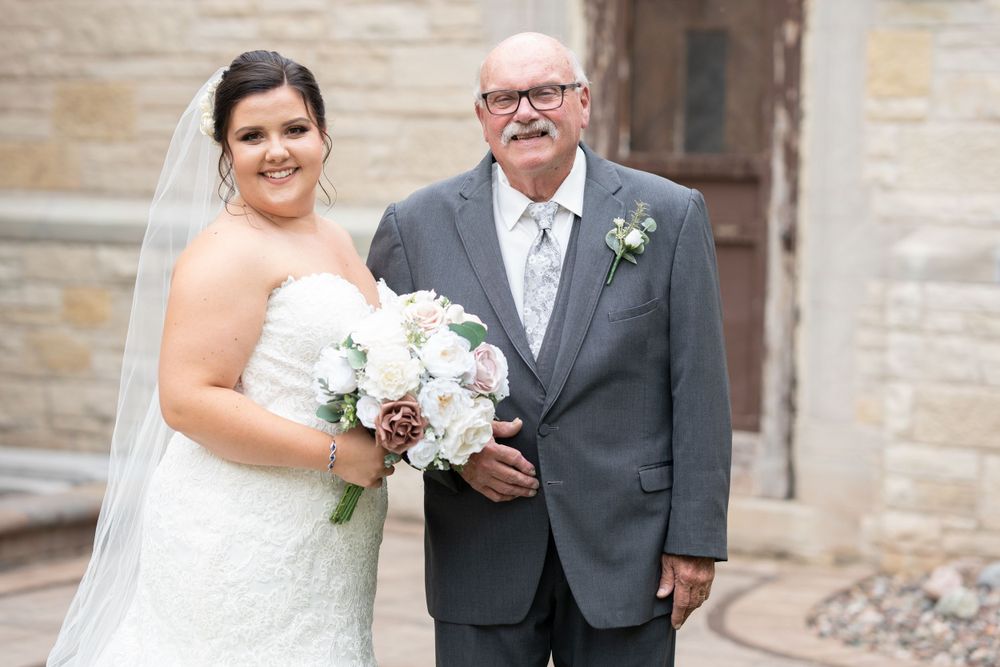 A touching wedding portrait outside a stone church building.