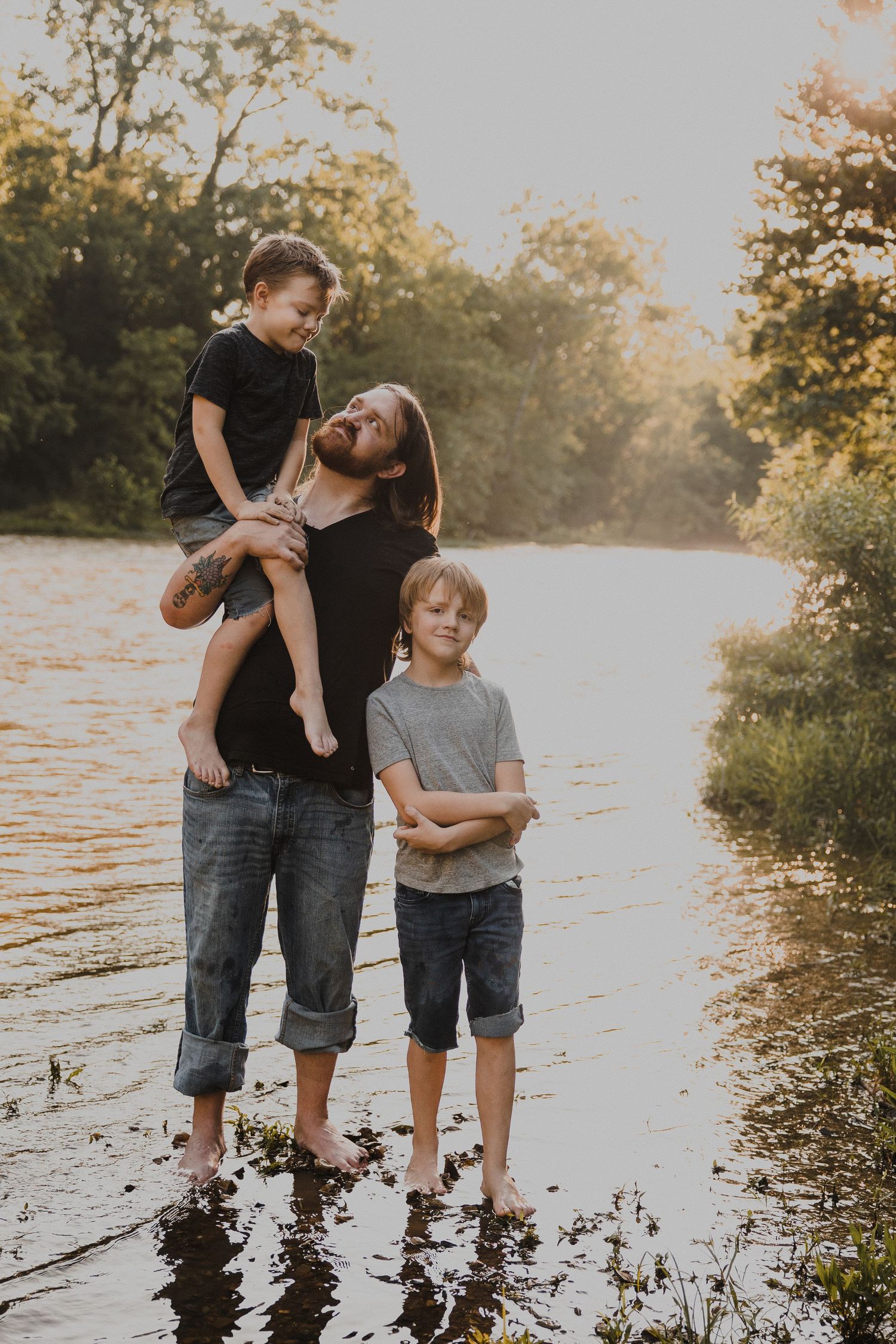 A playful family moment by the water during sunset.