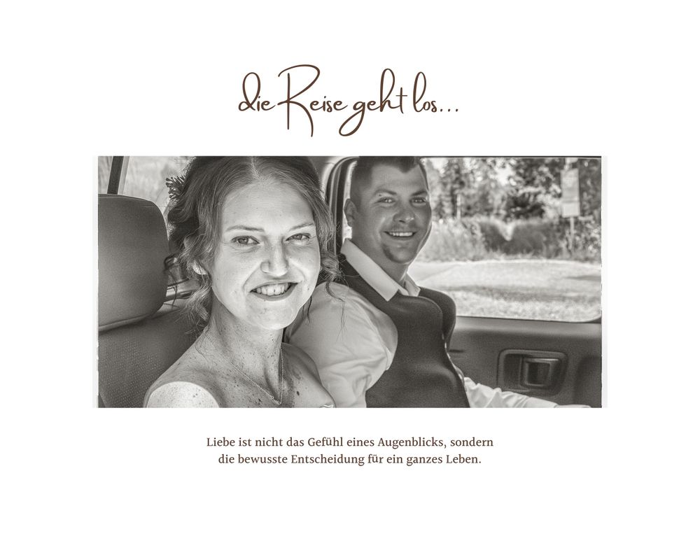 A black and white vintage photograph of two people smiling together in a car.