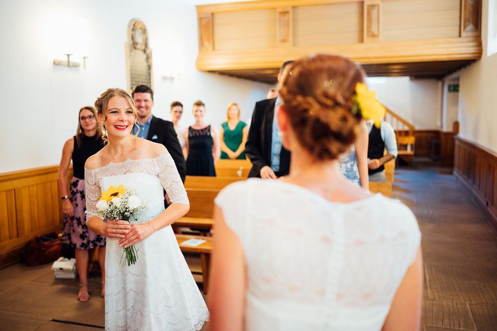 Intimate church gathering with guests seated in wooden pews.