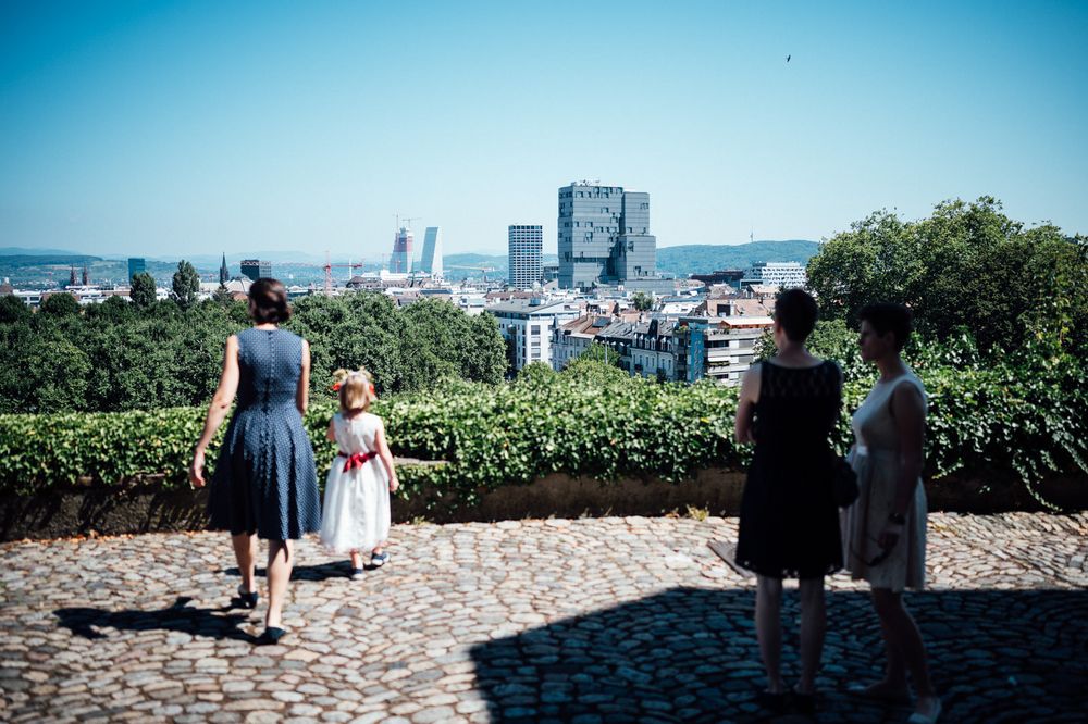 People viewing city skyline from elevated viewpoint on sunny day.