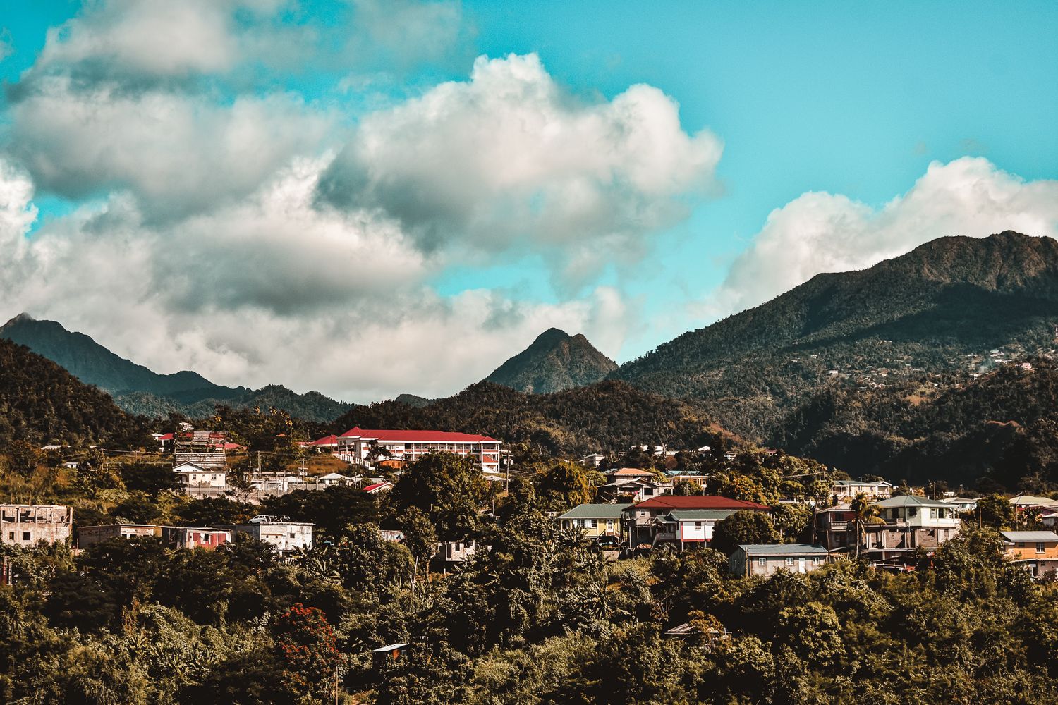 Mediterranean village nestled in mountains under bright turquoise sky.