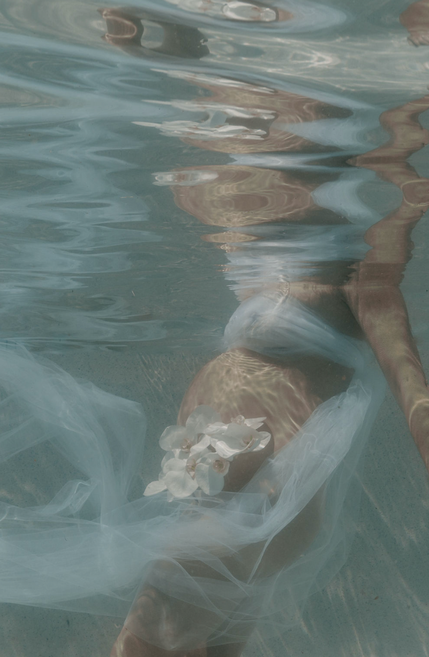 Underwater pregnant mother with flowers in a pool, during sunset in Byron Bay.