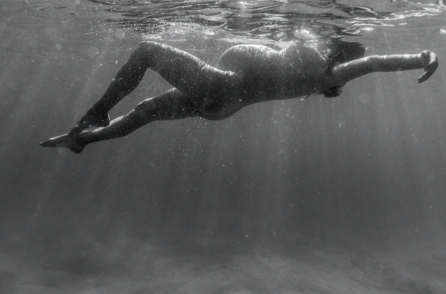 Pregnant woman in swimming pool during sunset in Byron Bay.