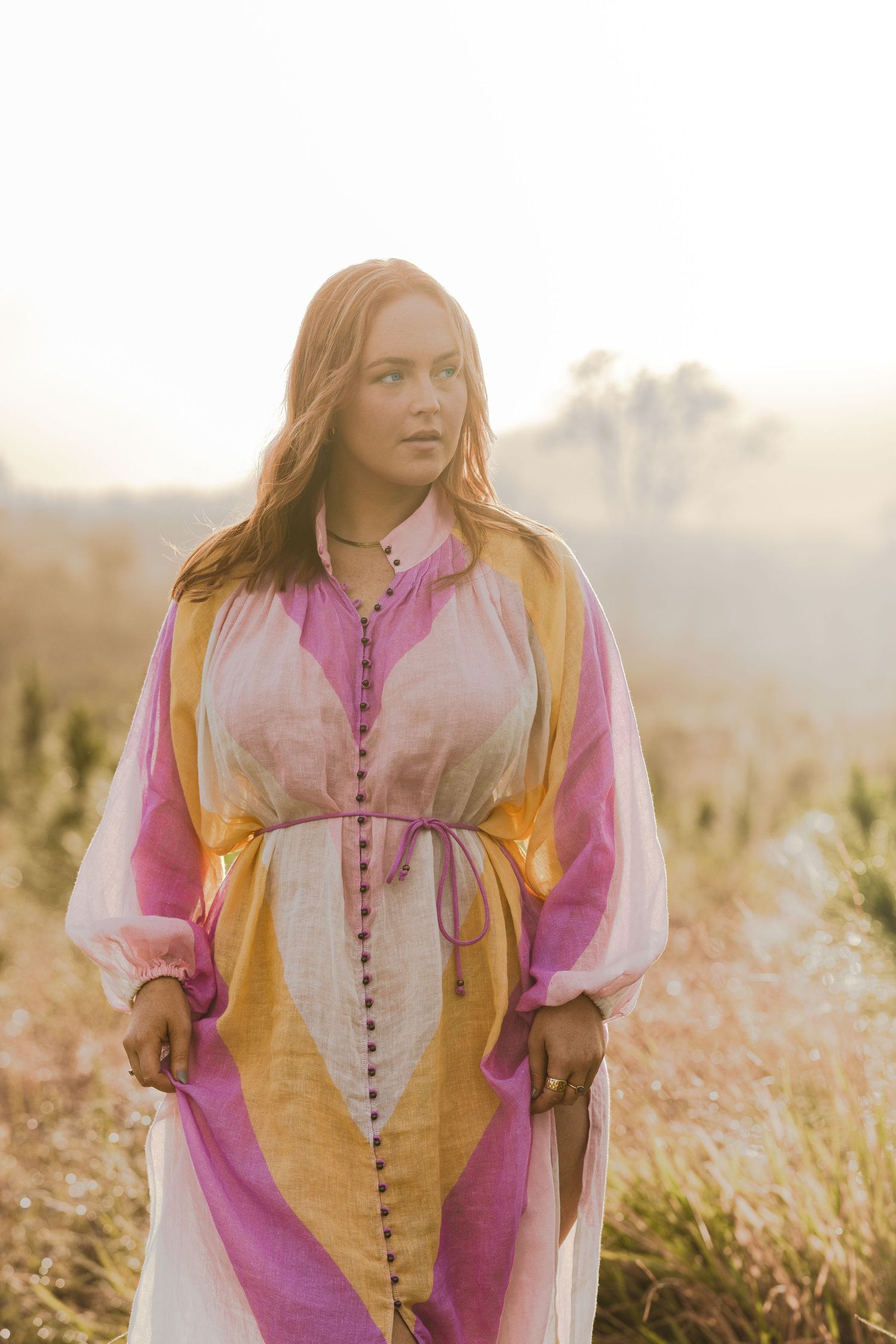 Model wearing bright clothes in wilderness at sunrise