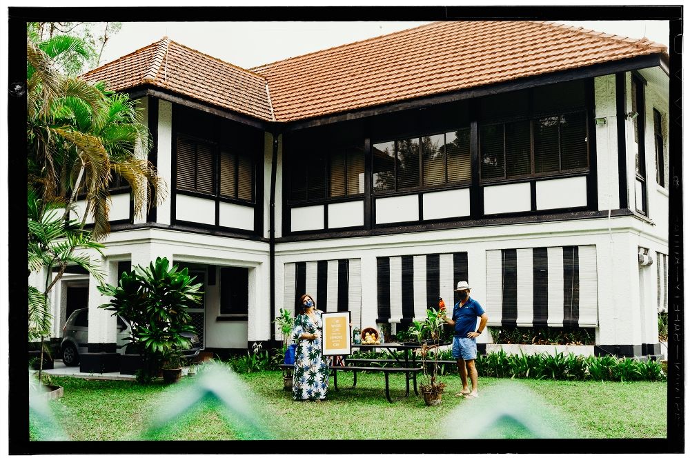 A couple outside their home in Singapore. They are wearing masks.