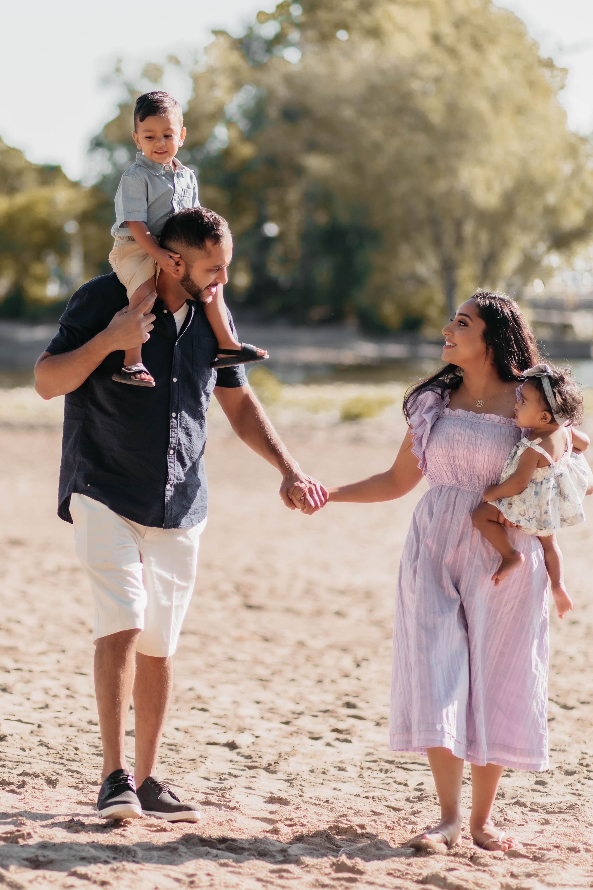 Happy family enjoying a playful moment on a sandy beach.