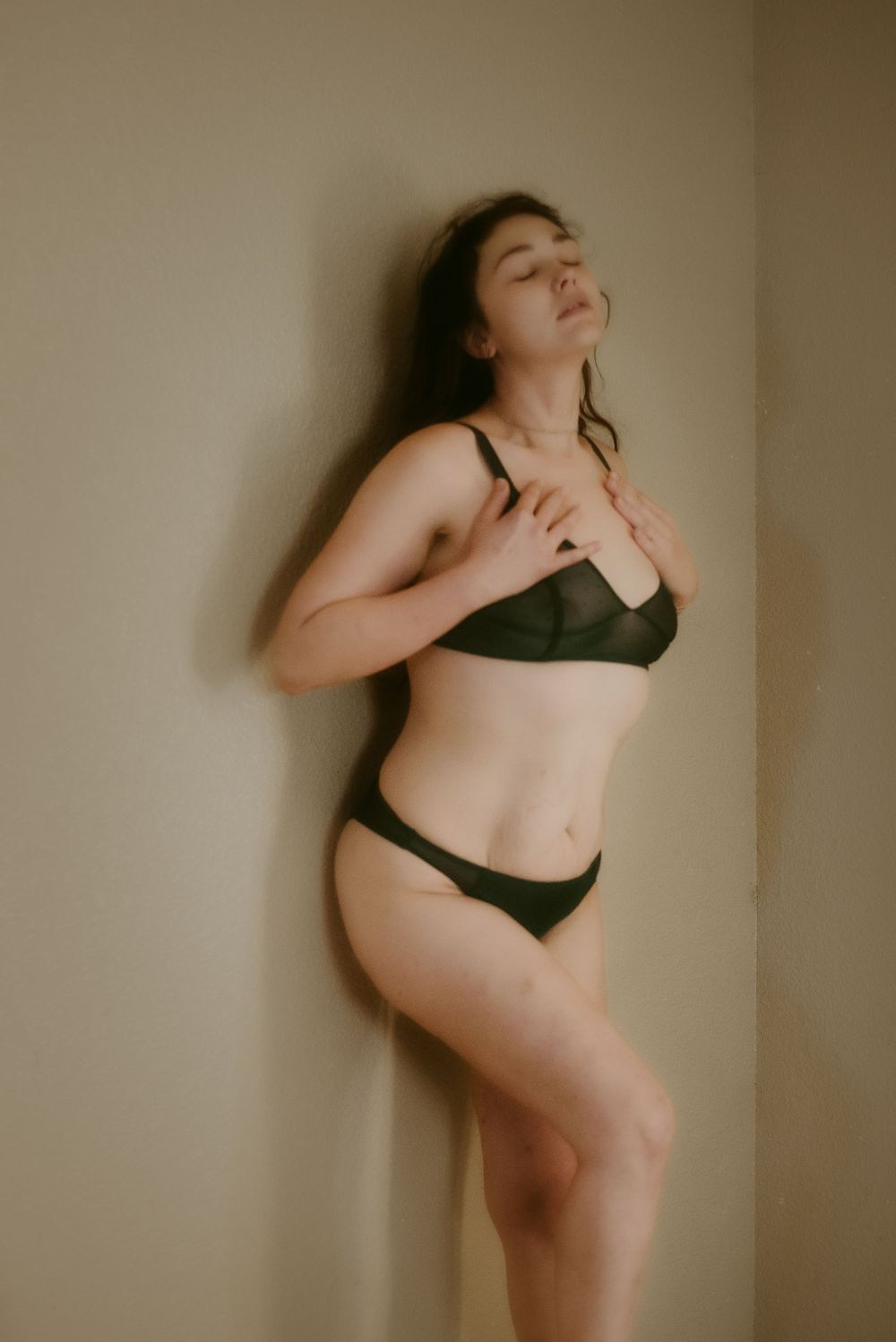 Artistic boudoir photograph in warm tones showing natural curves and expressions.