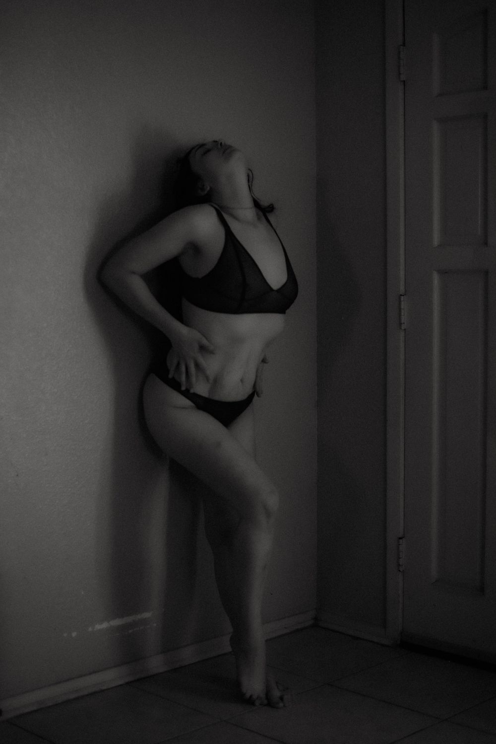 Dramatic black and white boudoir photo with strong shadows and poses.