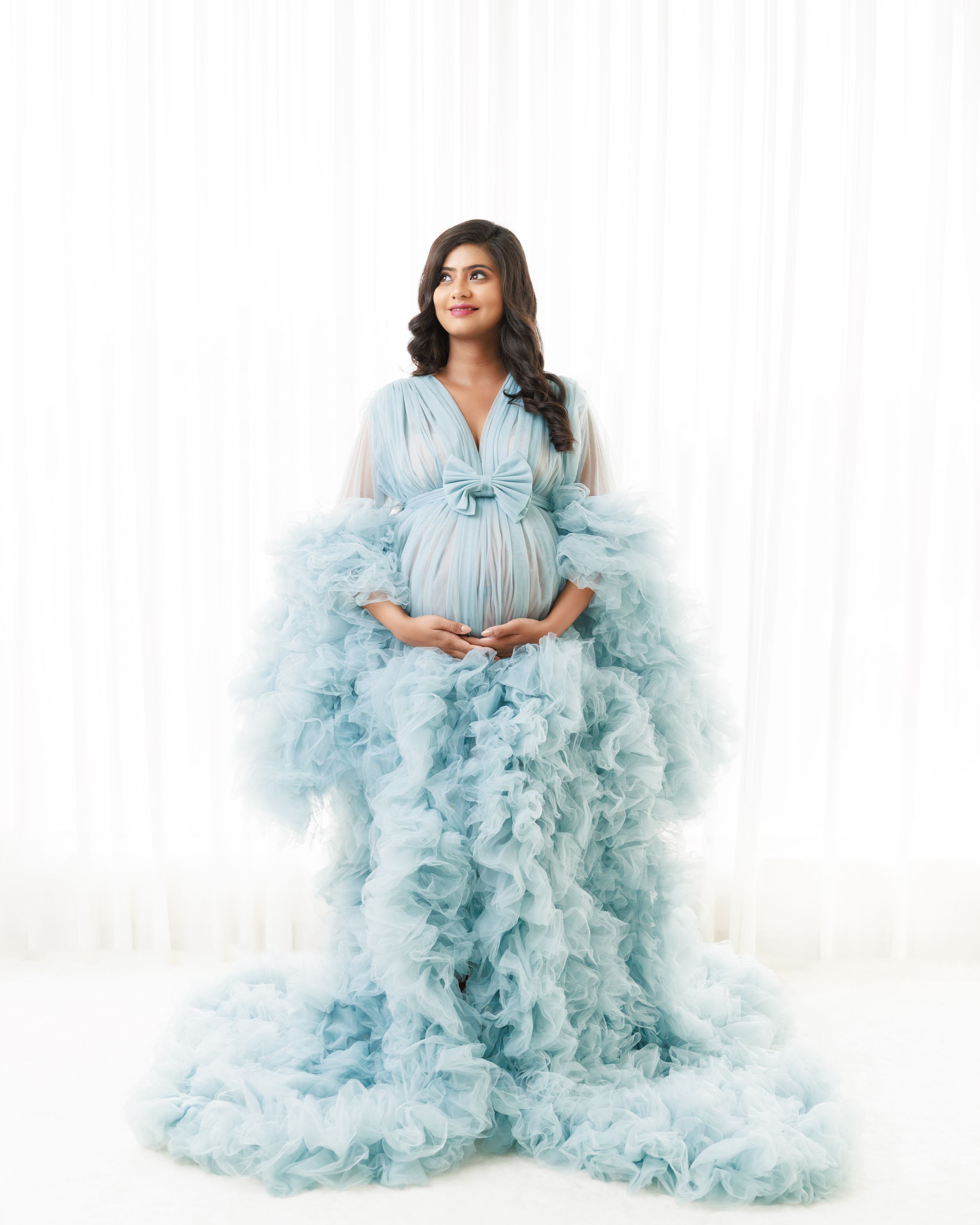 Ethereal maternity photo in flowing powder blue tulle gown with ruffled details.