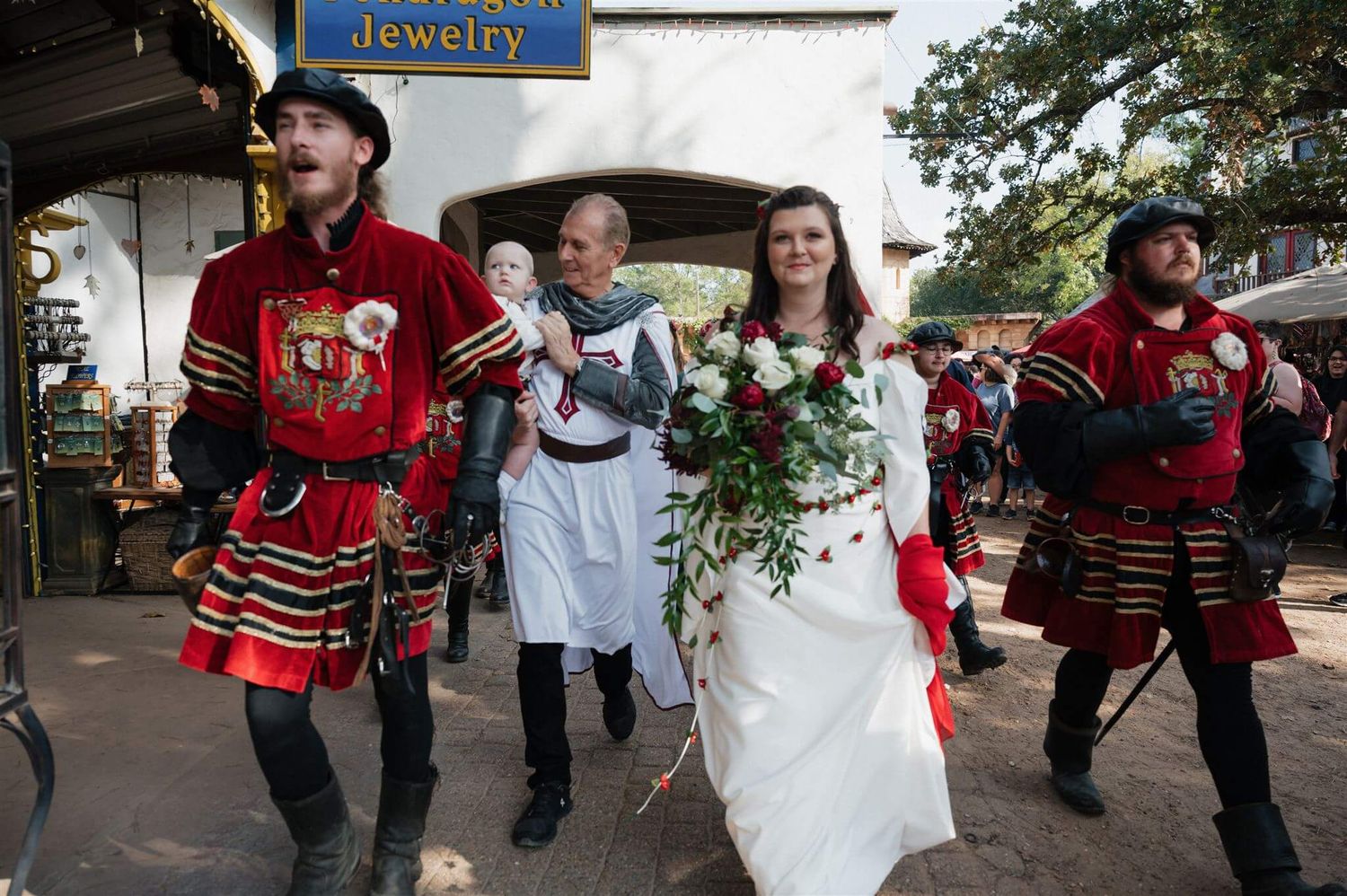 A wedding procession with Renaissance-costumed guards escorts a bride through a festival marketplace.