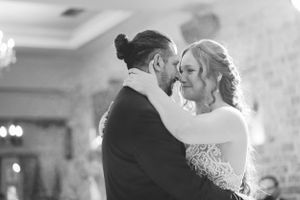 Romantic black and white portrait of couple dancing at wedding reception.