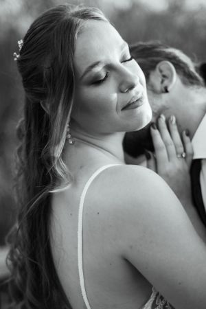 Black and white portrait of bride in lace dress with romantic lighting.