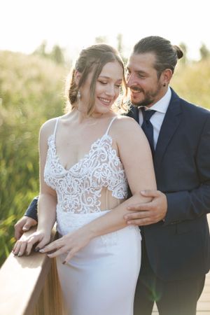 Romantic moment captured between newlyweds on outdoor wooden deck.