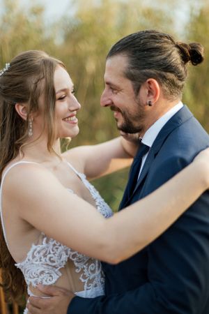 Intimate moment between newlyweds captured in natural outdoor setting.