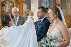 Traditional orthodox wedding ceremony with priest performing blessing ritual.