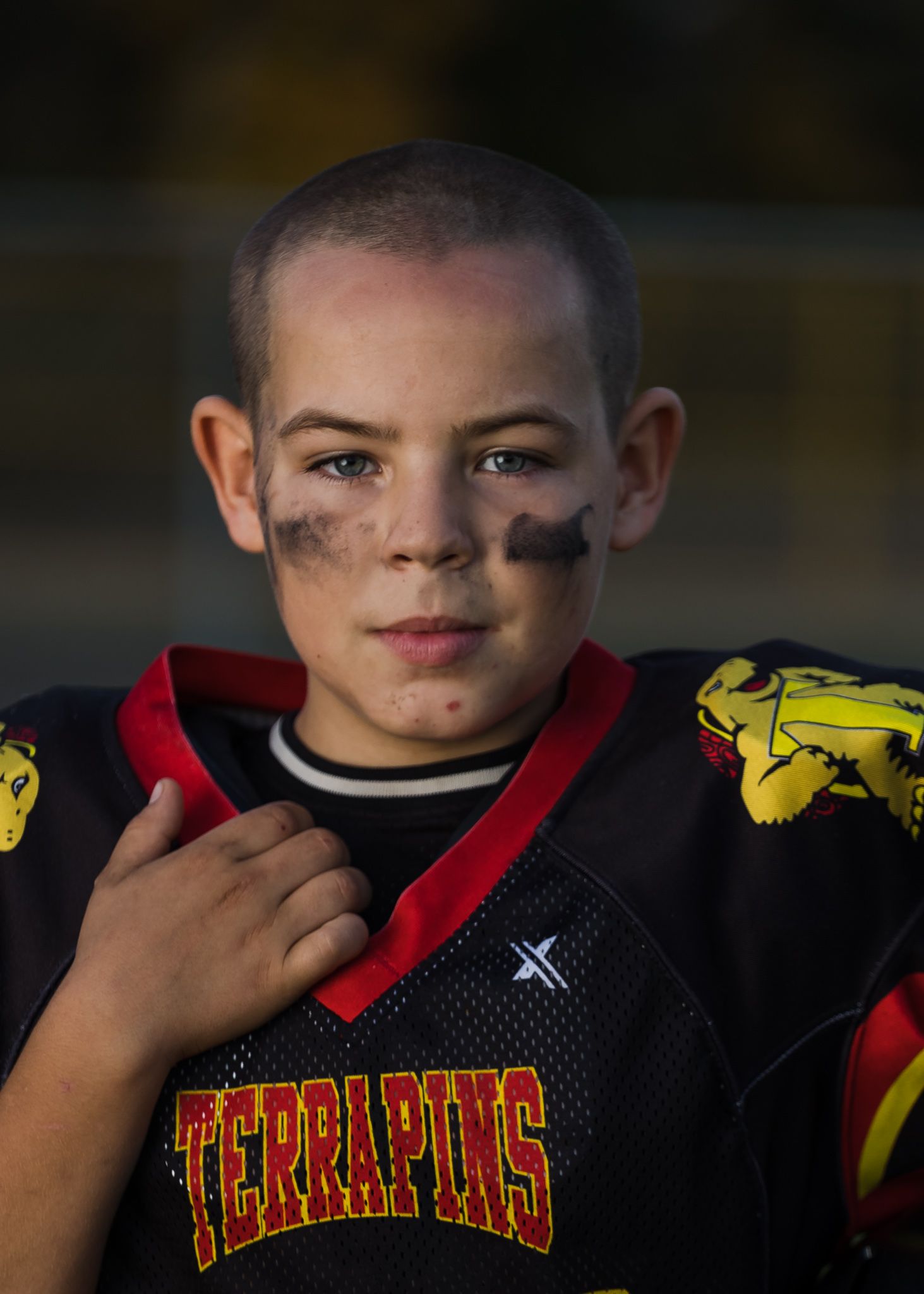 Young athlete wearing a red and black Terrapins sports jersey with face paint.