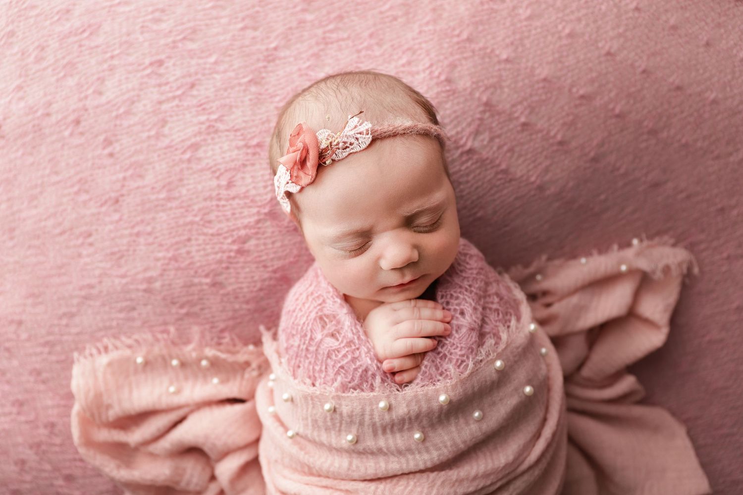 Fine art newborn portrait of baby girl in pink