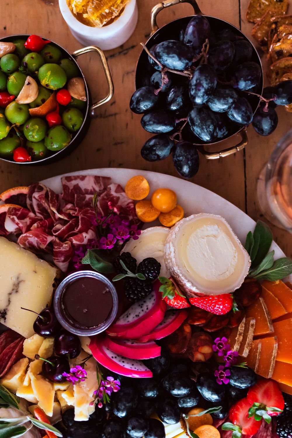 Overhead view of colorful charcuterie board with fruits, meats, cheeses and olives for winery and catering branding photography.