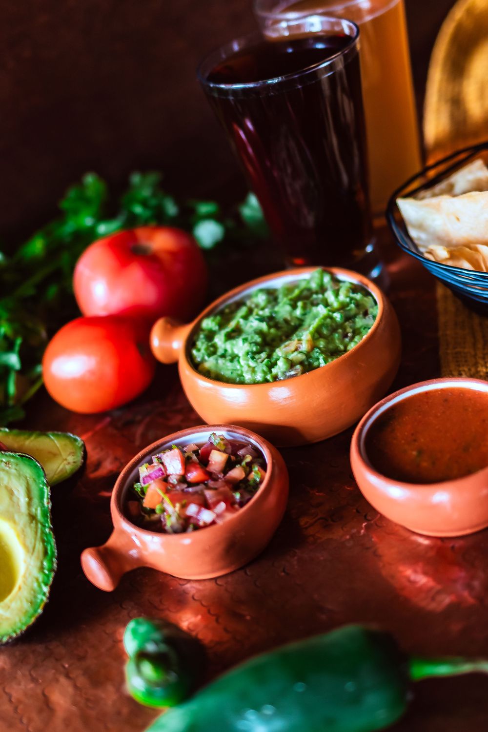 Close-up of Mexican appetizer spread with guacamole, pico de gallo, avocado and fresh tomatoes for restaurant branding photography.
