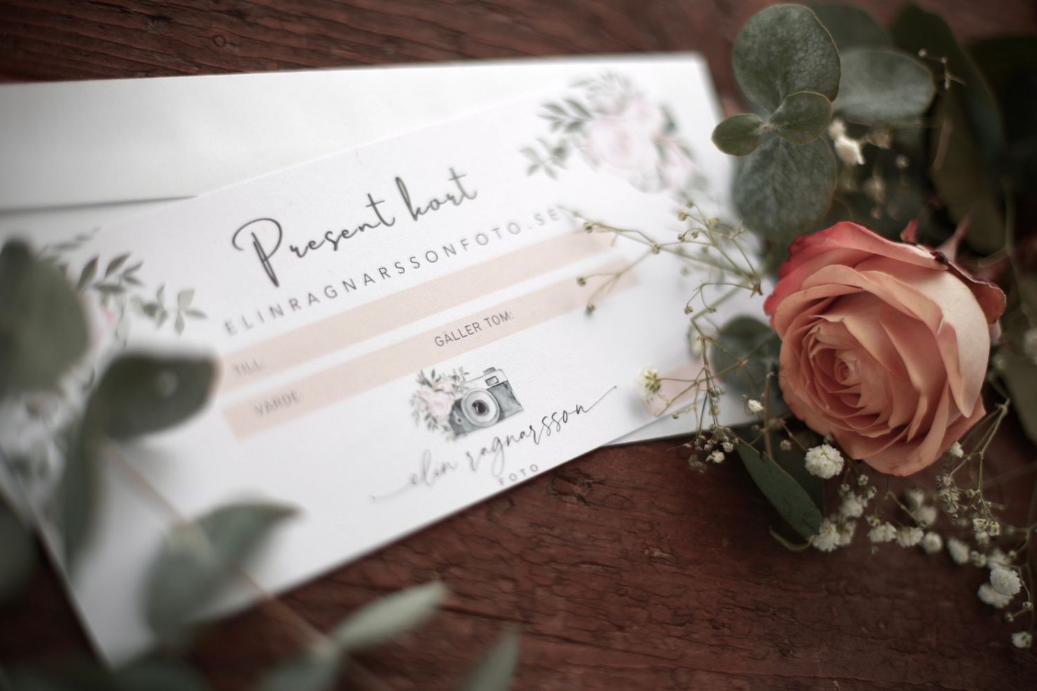 Elegant wedding gift card with pencils and a pink rose on a wooden surface.