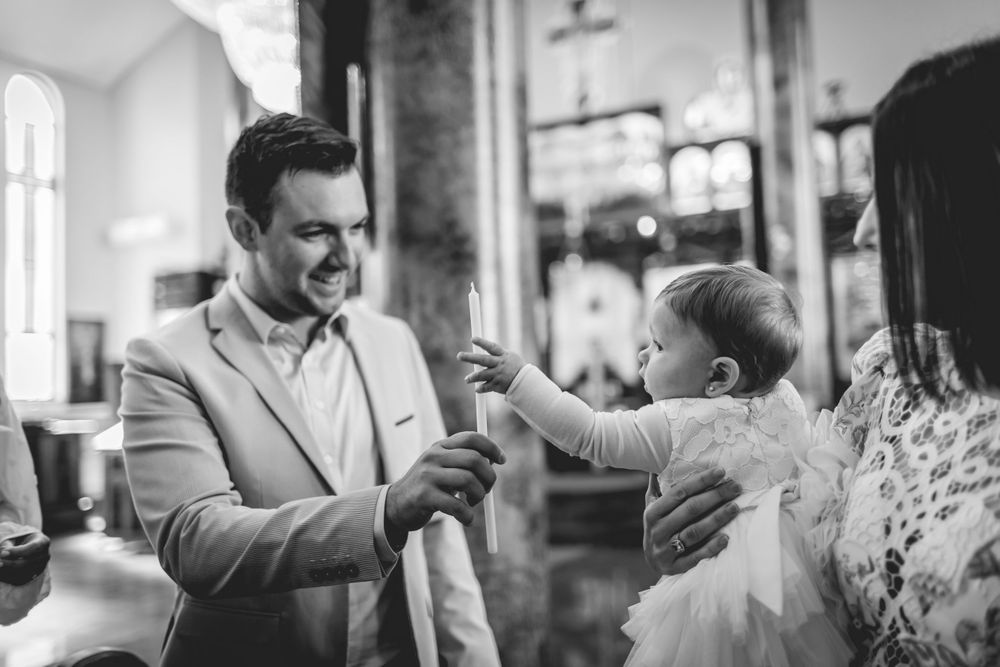 Black and white candid moment during religious ceremony in church interior.