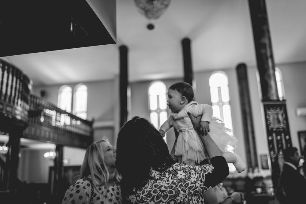Black and white photo of intimate gathering in church with arched windows.