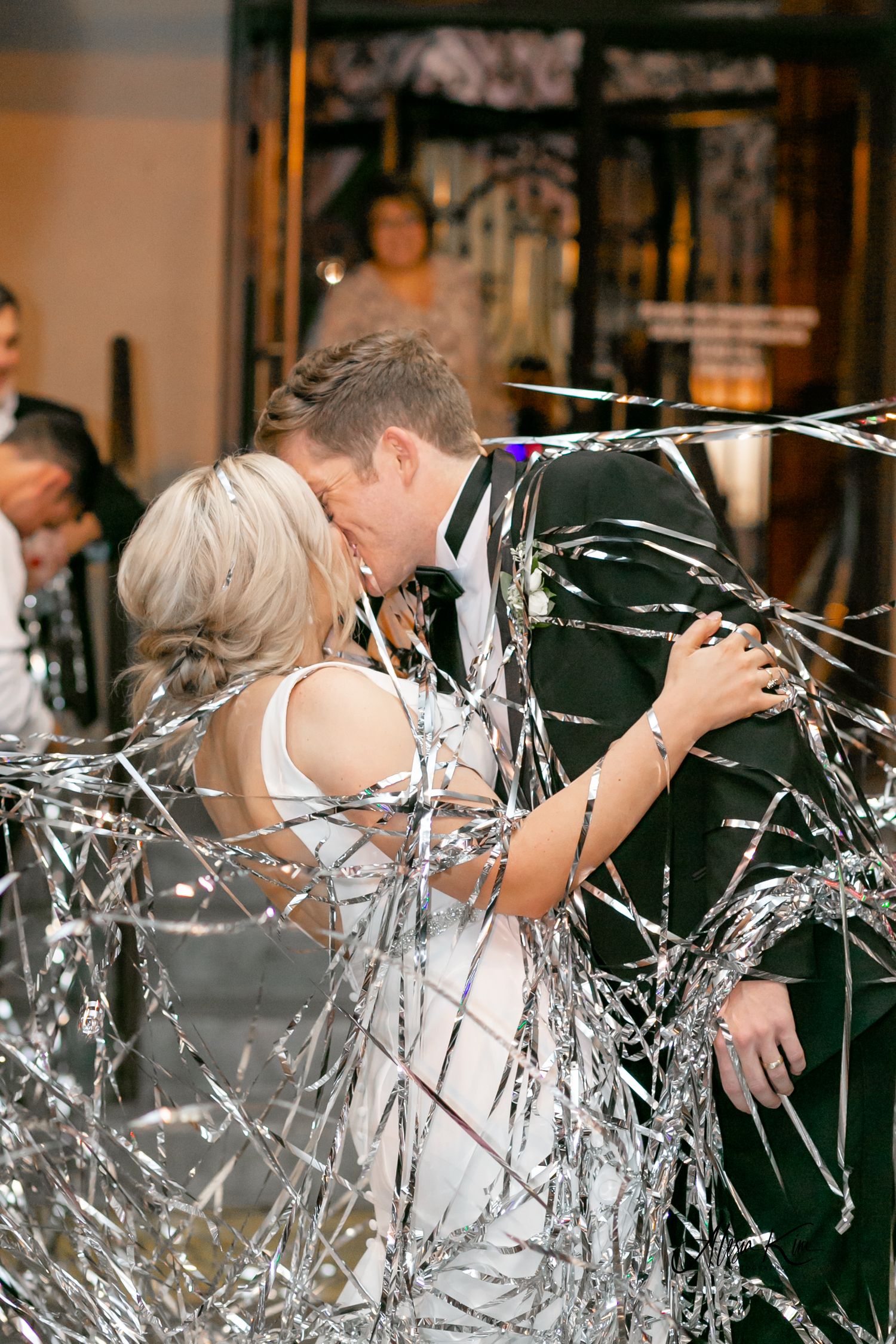 bride and groom kiss in streamer exit Baton Rouge wedding planner
