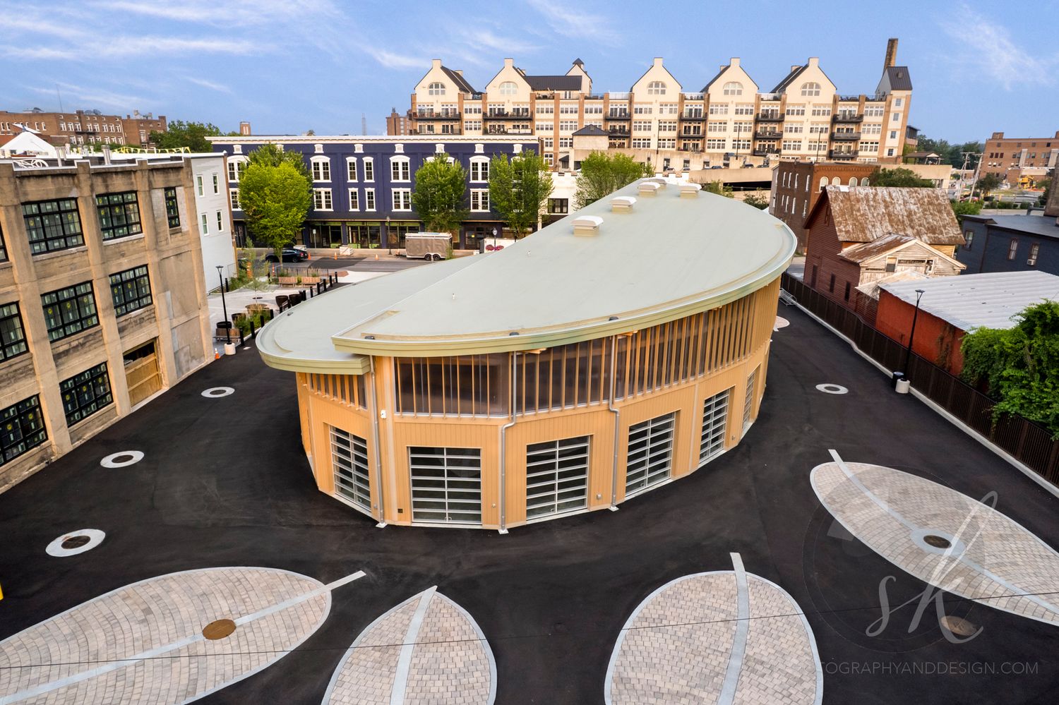 Aerial photo of a unique new commercial building on broad street in Glens Falls, NY surrounded by a decorative paved plaza.