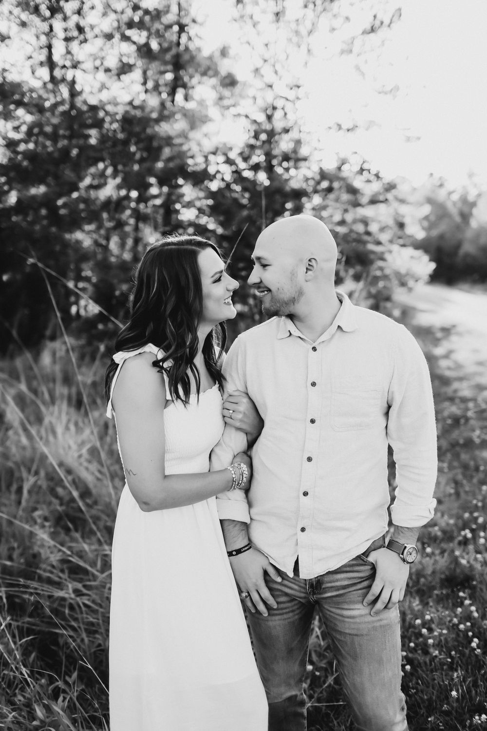 Black and white outdoor portrait series of couple in white clothing sharing romantic moments.