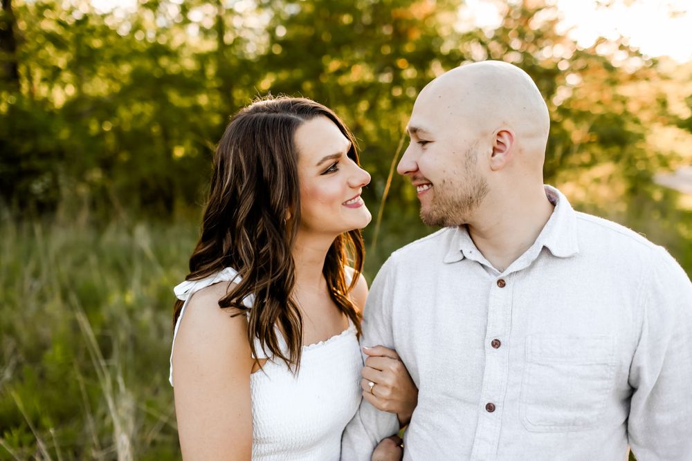 Sunset engagement photos showing couple in white clothing sharing intimate moments in nature.