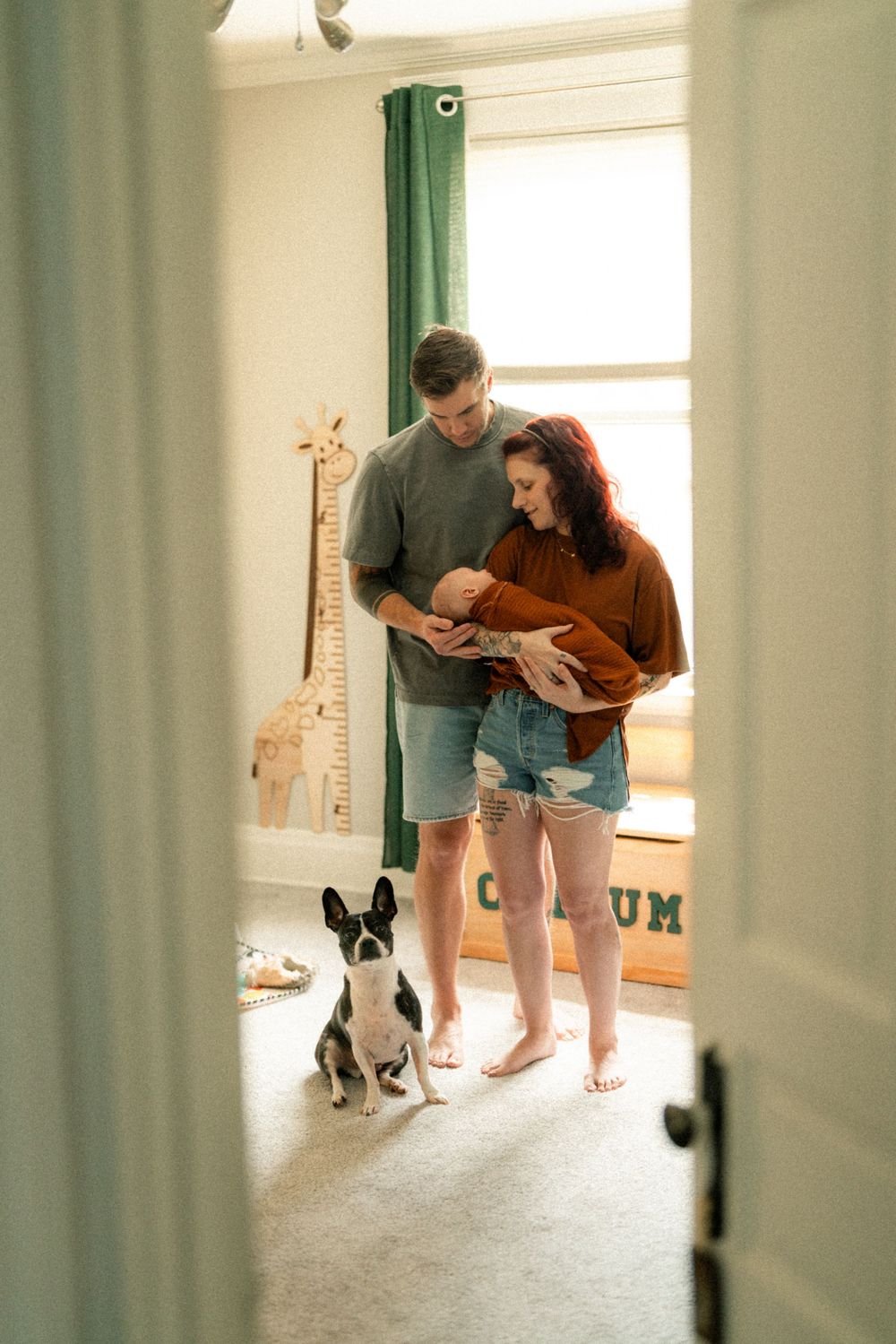 Young couple holding their newborn child inside their home nursery in Cincinnati Ohio