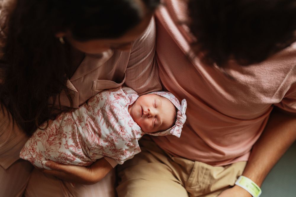 Young couple holding their newborn child inside a hospital in Northern Kentucky.