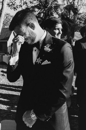 A groom crying after seeing his beautiful bride.