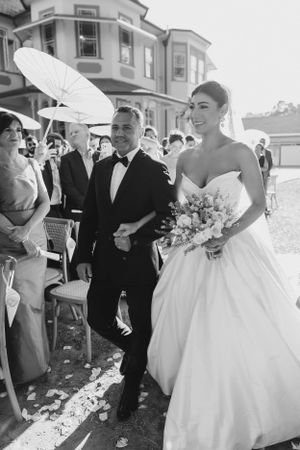 A bride walking up to the groom with her dad.