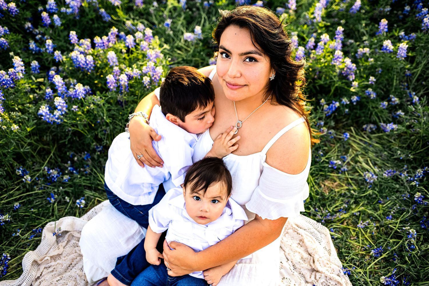 Beautiful, candid San Antonio mom with her children in the iconic Texas bluebonnets in Spicewood, Texas at Muleshoe Bend Recreational Area.